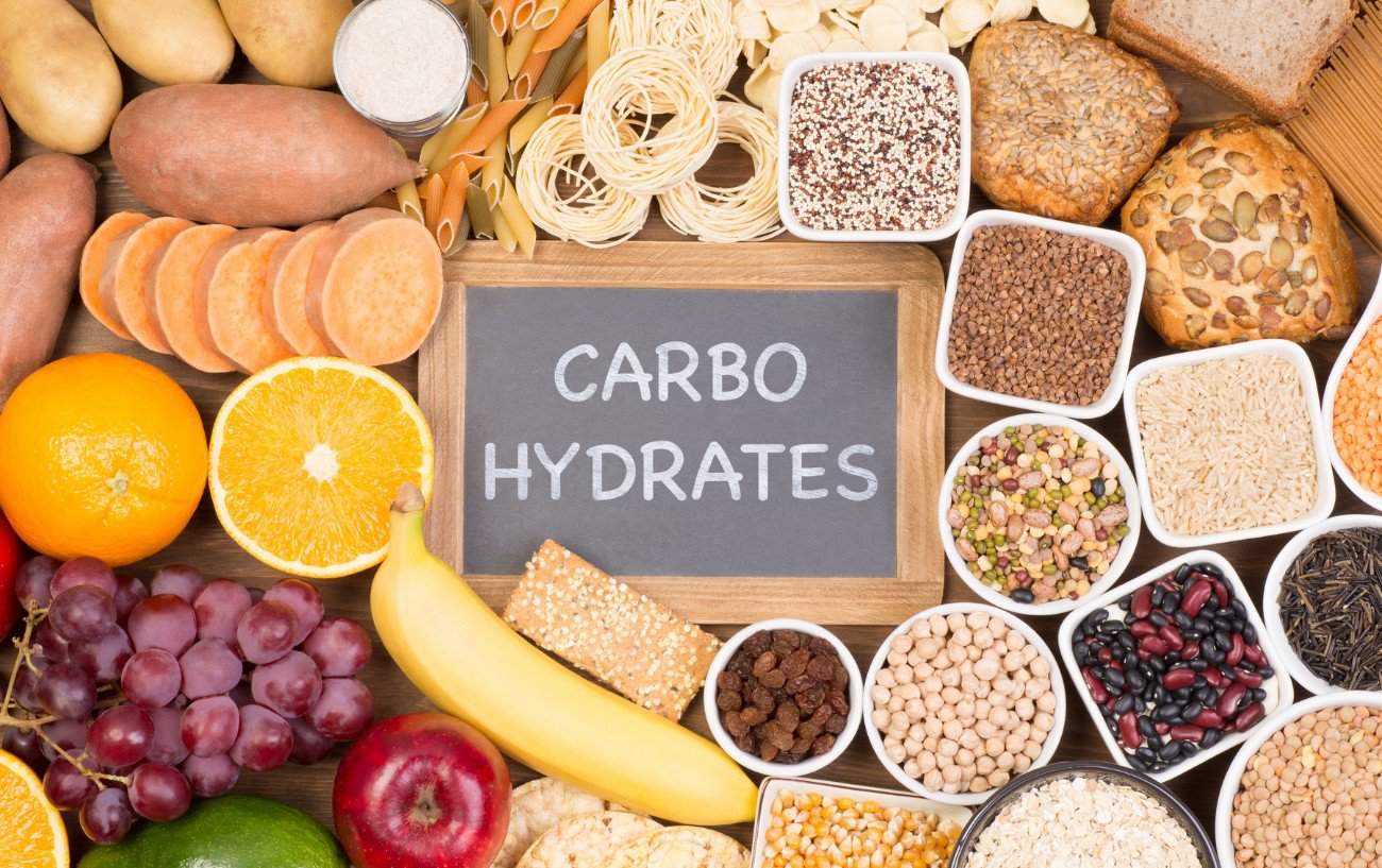 A collection of food with a sign that reads carbohydrates in the center.