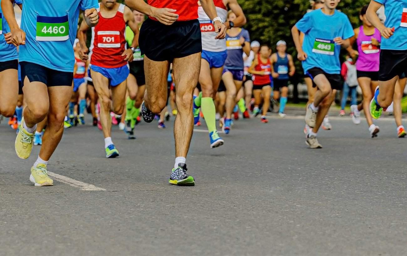 A group of marathoner runners filling the street. 