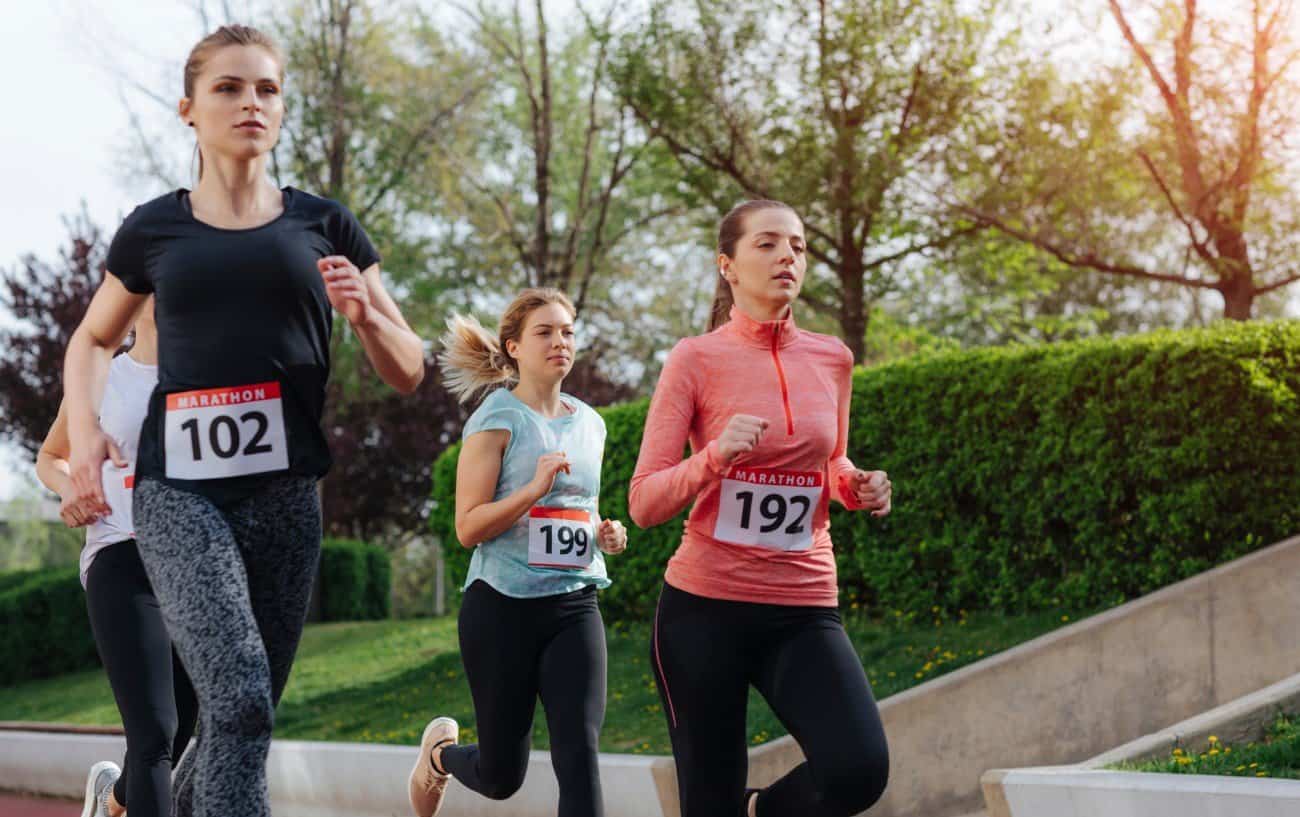 A group of three women running a marathon.