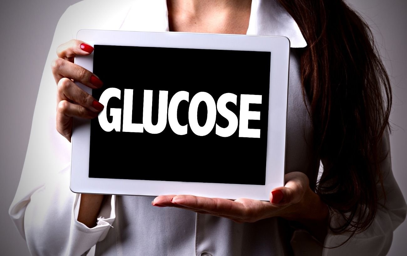 A doctor holding a tablet with the word glucose on it.