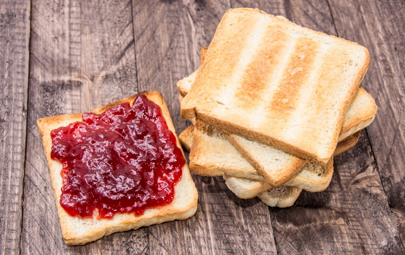 A stack of toast and strawberry jelly.
