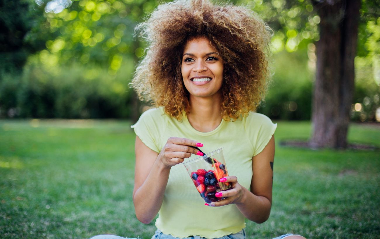 A person eating a fruit salad. 