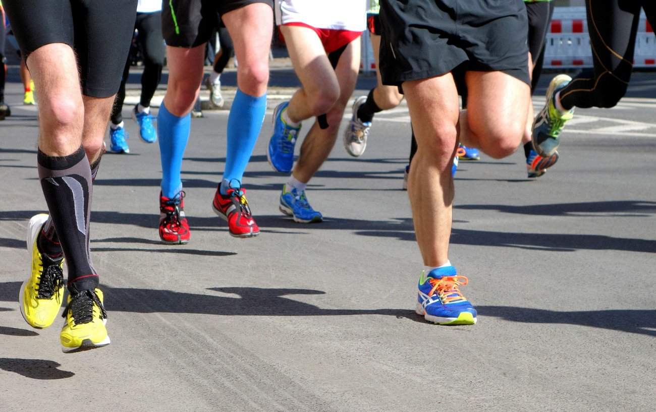 people's feet running on a road