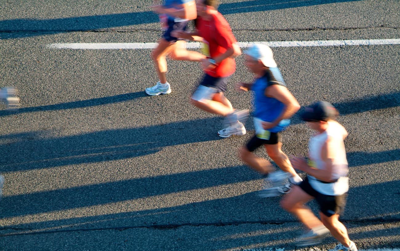 4 people running along a road
