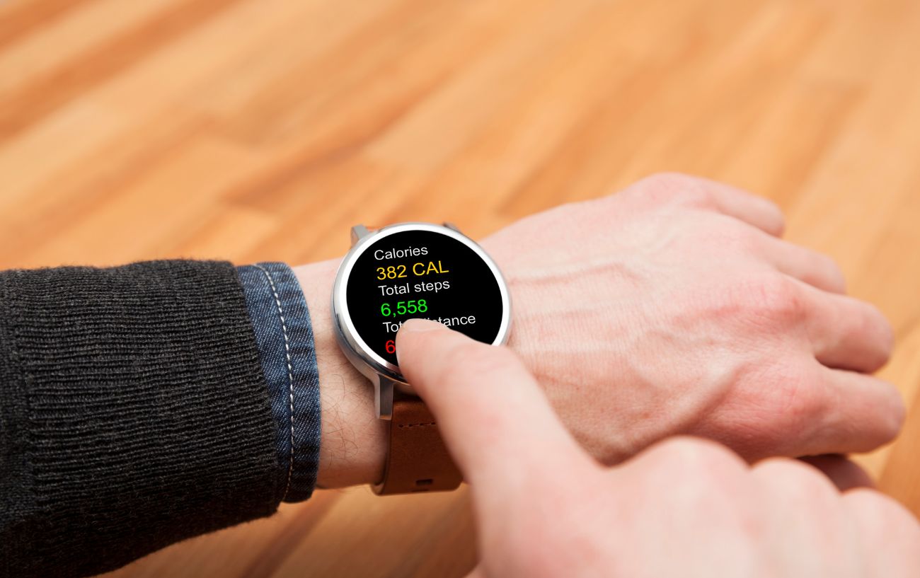 A person pointing at their steps on their watch.