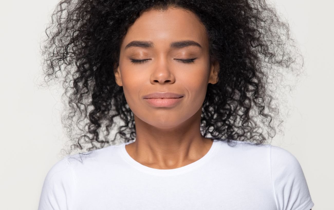 A person with their eyes closed, breathing through their nose.