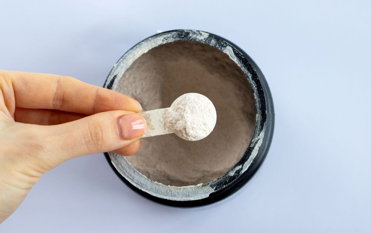 a hand holding a spoon of powder
